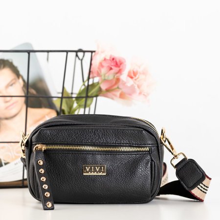 Eine kleine Damenhandtasche auf einem schwarzen Rahmen - Handtaschen