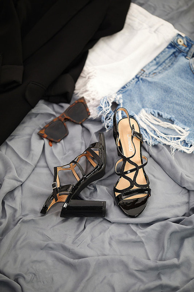 Schwarze Damensandalen lackiert auf dem Ovid-Footwear-Pfosten