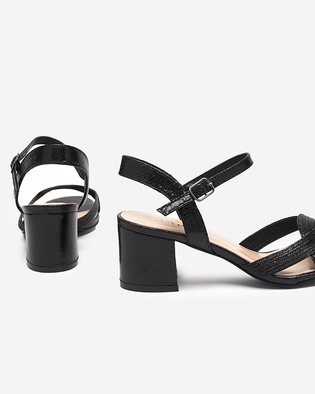 Schwarze Damensandale auf dem Pfosten. Offal- Schuhe