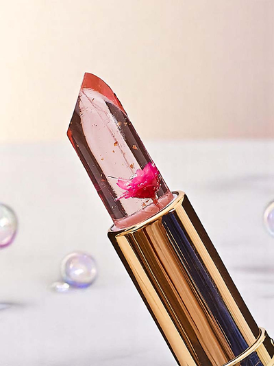 Transparenter Lipgloss mit eingelegten rosa Blüten