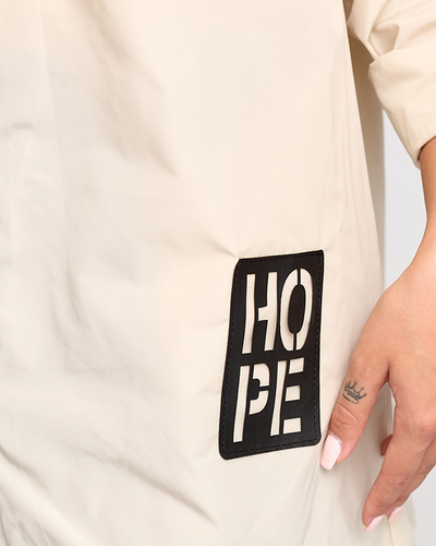 Бежева жіноча подовжена куртка-ветровка з бейджем - Одяг